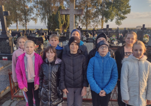 Uczniowie klasy IV-VI zapalili znicze na grobie ofiar II wojny światowej na cmentarzu w Łaznowie